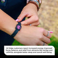 Close-up of the AV Edge Advanced Black/Pink frequency wristband tucked under a red quilted jacket, featuring HEF Technology that might support enhanced cellular energy, focus, and natural EMF protection for active, outdoor lifestyles.