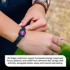 Close-up of the AV Edge Advanced Black/Pink frequency wristband tucked under a red quilted jacket, featuring HEF Technology that might support enhanced cellular energy, focus, and natural EMF protection for active, outdoor lifestyles.