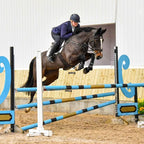 Professional showjumper Laura Goodall clearing an oxer jump, showing AV Edge Horse Bridle Patches. This FEI-legal equine calming alternative may support biomechanical coordination and focus while providing anti-doping confidence.