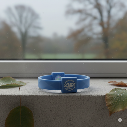 Sky blue AV Edge Advanced wristband resting on a gray stone surface with a blurred autumn background of mist, bare branches, and fallen leaves.