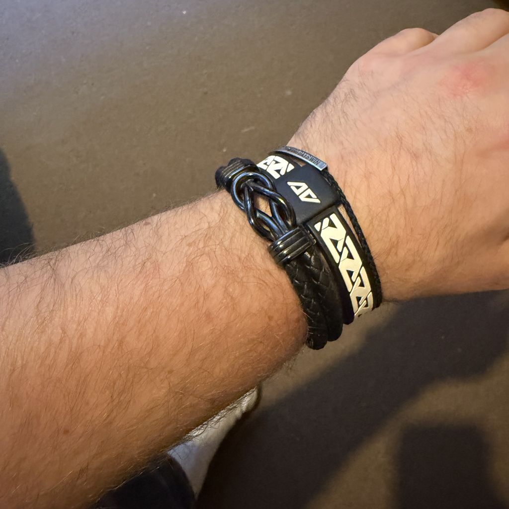 Close-up of Ben Davies golf coach wrist wearing a black braided AV Edge Legend Bracelet with EF technology, frequencies, not magnets, that may protect against modern technology EMFs and improve health and performance by stimulating the production of adenosine triphosphate/ATP.