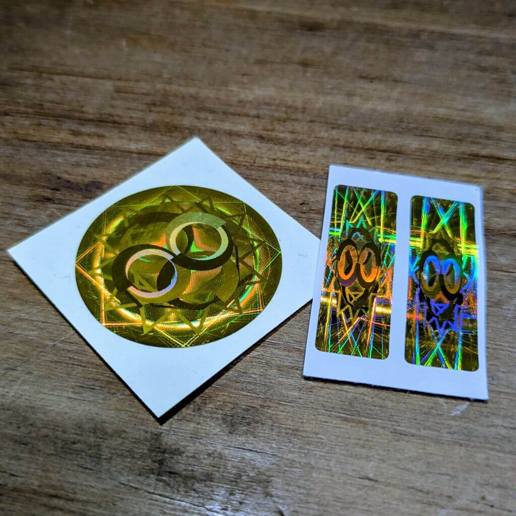 Device Filter Starter Duo showing a gold circular EMF protect filter for laptop or tablet alongside two gold rectangular cell phone EMF protect filters on backing paper.